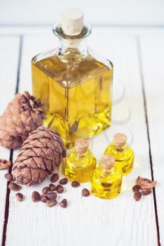 The cedar oil in a glass bottle on a white wooden background. Source of essential fatty acids for healthy nutrition