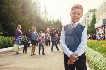 The first time in first class: happy schoolboy at school background