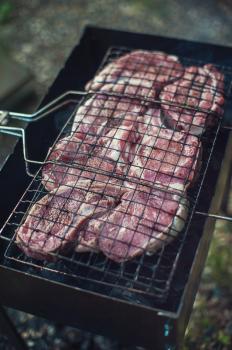 Grilling fresh entrecote pork on a grill