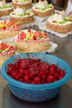 Bowl of cherry on cake production in factory