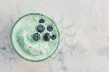 Blueberry smoothie on a white concrete background