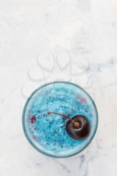 Blue cherry smoothie on a white concrete background