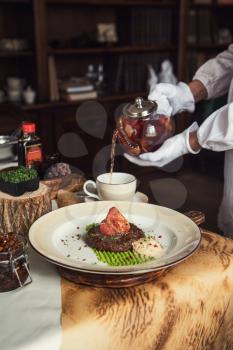 High kitchen: grilled beef meat on msshed green peanut with burdock root puree. Servant pours tea.