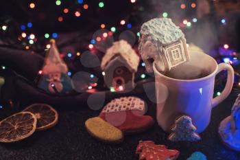 Christmas cookies and cup of tea on daark color bokeh lights background