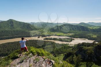 Man standing on top of cliff in summer beauty day in Altai mountains