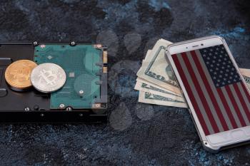 Bitcoin coin on HDD with smartphone with USA flag