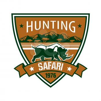 Hunting and safari badge. African rhino with mountain landscape on heraldic shield with ribbon banner. Hunting club symbol, safari trip or wildlife tourism design