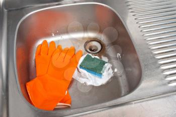 Cleaning the kitchen sink with a glove 