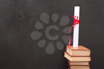 Chalkboard with a diploma and books