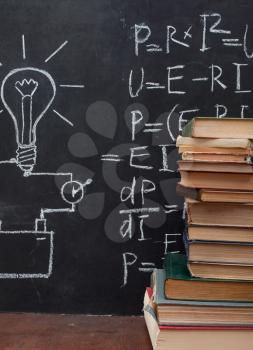 Light bulb drawn on blackboard and books