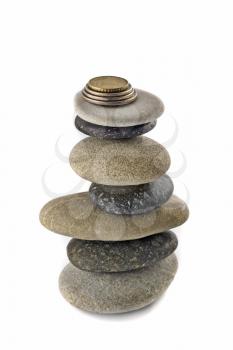 Stability, wealth and welfare - Balanced stone stack or tower with coins on top over white