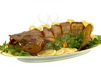 Tasty dinner - bloated fresh-water catfish (sheatfish) with lemon and parsley on the plate