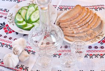 Vodka, bread and sliced cucumber on towel