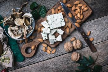 Cheese with dill, nuts mushrooms  and on wooden table  in rustic style