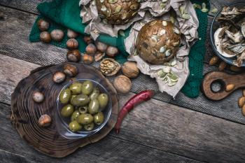 healthy eating olives, nuts mushrooms  and bread buns  in rustic style