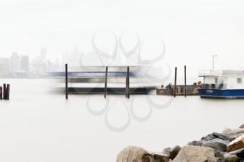 New York, USA-June 2, 2015: East River Ferry coming in for docking on a foggy day.