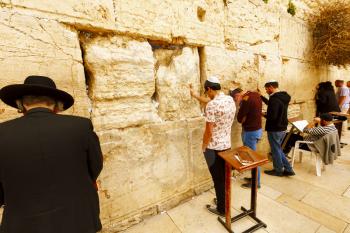 Jerusalem, Israel-March 14, 2017: Jews pray at The Western Wall - the holiest place where Jews are permitted to pray, though it is not the holiest site in the Jewish faith, which lies behind it, on Te