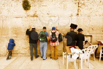 Jerusalem, Israel-March 14, 2017: Jews pray at The Western Wall - the holiest place where Jews are permitted to pray, though it is not the holiest site in the Jewish faith, which lies behind it, on Te