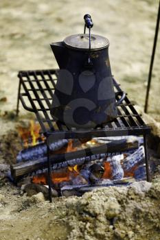 Ancient tea kettle on campfire.