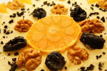 Closeup of tasty pie with orange, nuts and prunes