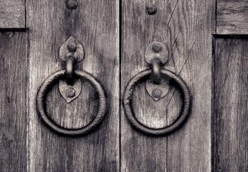 ancient wooden gate with two door knocker rings
