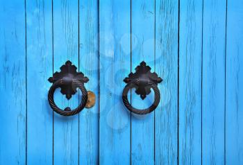 Bright blue wooden door with round handles