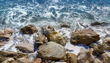 Foamy sea water near a rocky shore