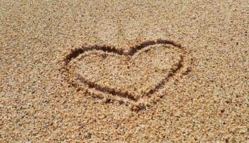 Drawing of abstract heart in the sand on beach