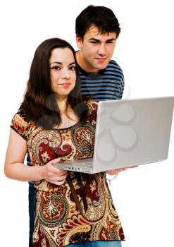 Royalty Free Photo of a Young Couple Standing Together Holding a Laptop