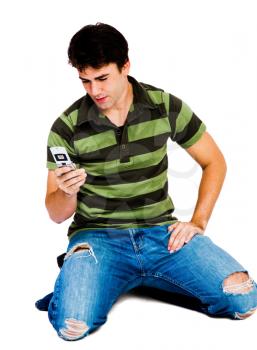 Royalty Free Photo of a Man Sitting on his Knees Texting on his Mobile Phone