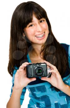 Portrait of a teenager photographing with a camera and smiling isolated over white