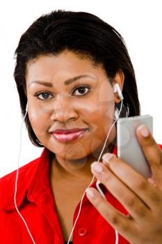 African woman listening to music on MP3 player isolated over white