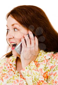 Woman talking on a mobile phone and looking surprised isolated over white