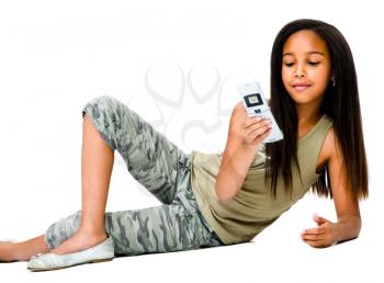 Child text messaging on a mobile phone and posing isolated over white
