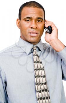 Serious businessman talking on a mobile phone isolated over white