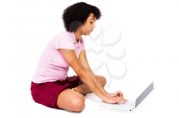 Mixed race teenage girl using a laptop isolated over white