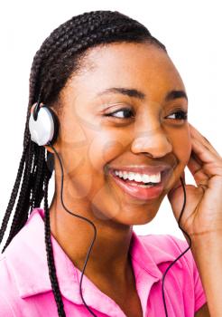 Confident teenage girl listening to music on headphones isolated over white