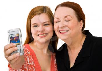 Close-up of women photographing themself with a mobile phone isolated over white