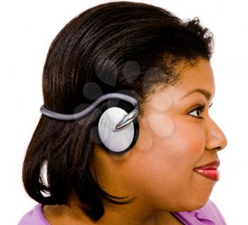 Woman wearing headphones and listening to music isolated over white