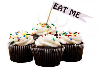 Close-up of EAT ME text tag on a cupcakes isolated over white
