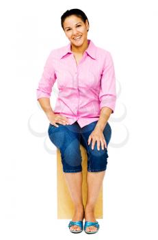 Confident woman sitting on a stool and smiling isolated over white