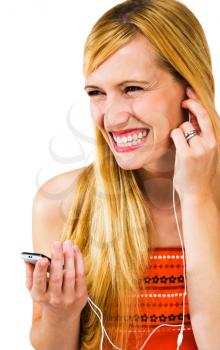 Confident woman listening to music on MP3 player isolated over white