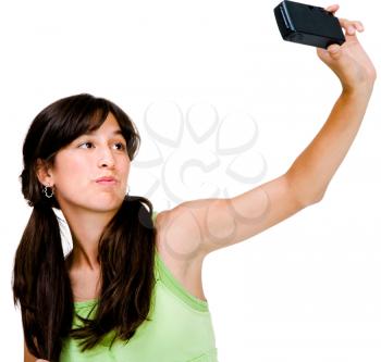 Asian teenage girl photographing herself with a camera and posing isolated over white