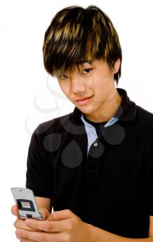Smiling teenage boy text messaging on a mobile phone isolated over white