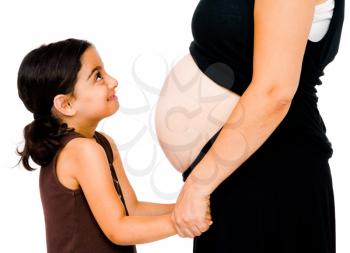 Close-up of a girl smiling with her pregnant mother isolated over white