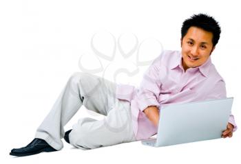 Asian man using a laptop and smiling isolated over white