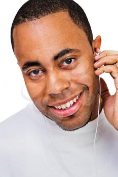 Young man listening to music on a MP3 player isolated over white