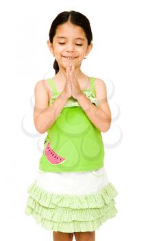 Girl standing in prayer position and smiling isolated over white