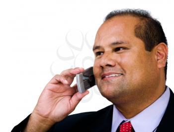 Businessman talking on a mobile phone and smiling isolated over white