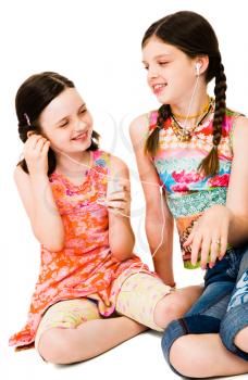 Smiling girls listening to MP3 player isolated over white